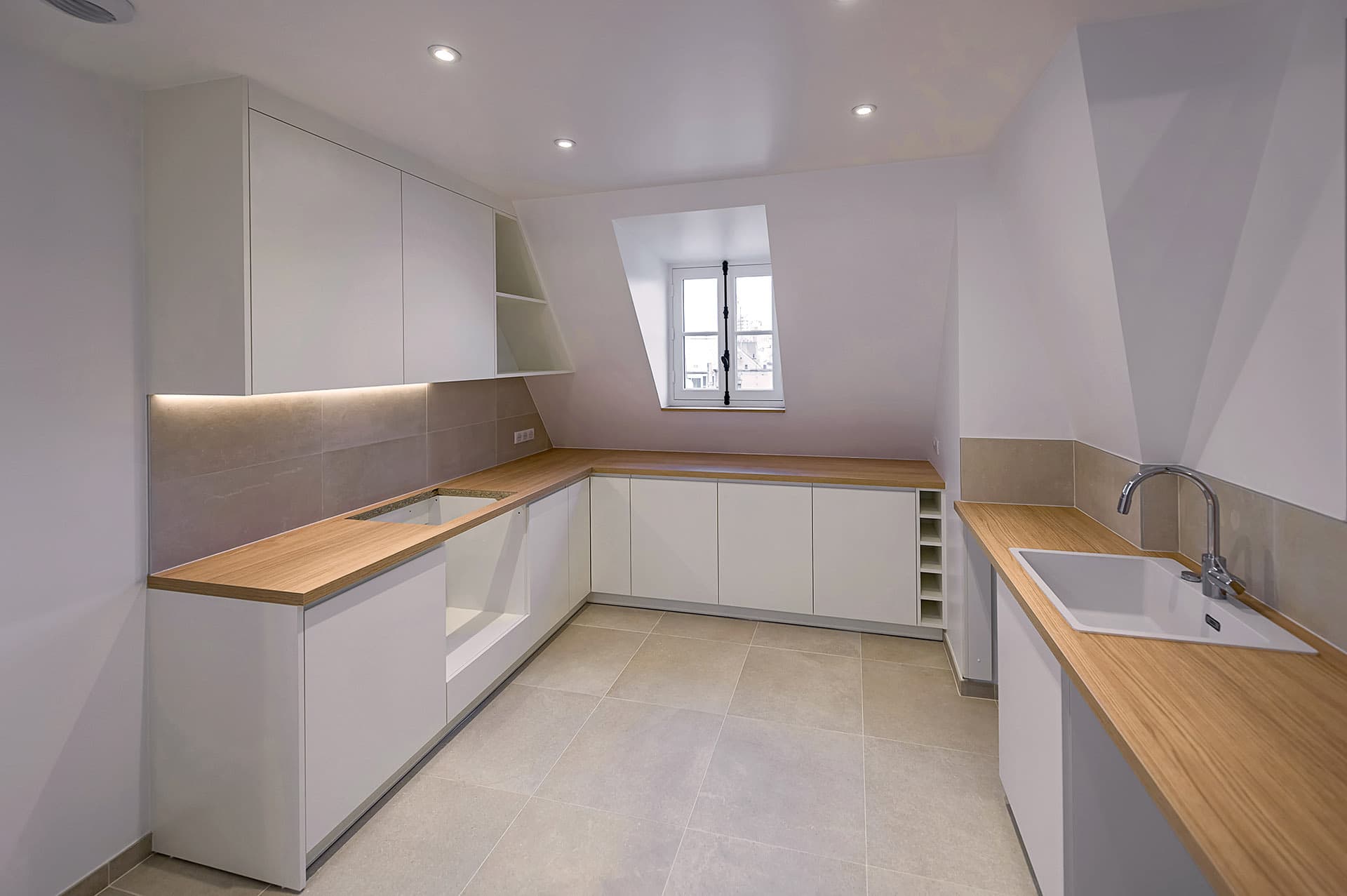 Cuisine moderne blanche avec plan de travail en bois et crédence carrelée