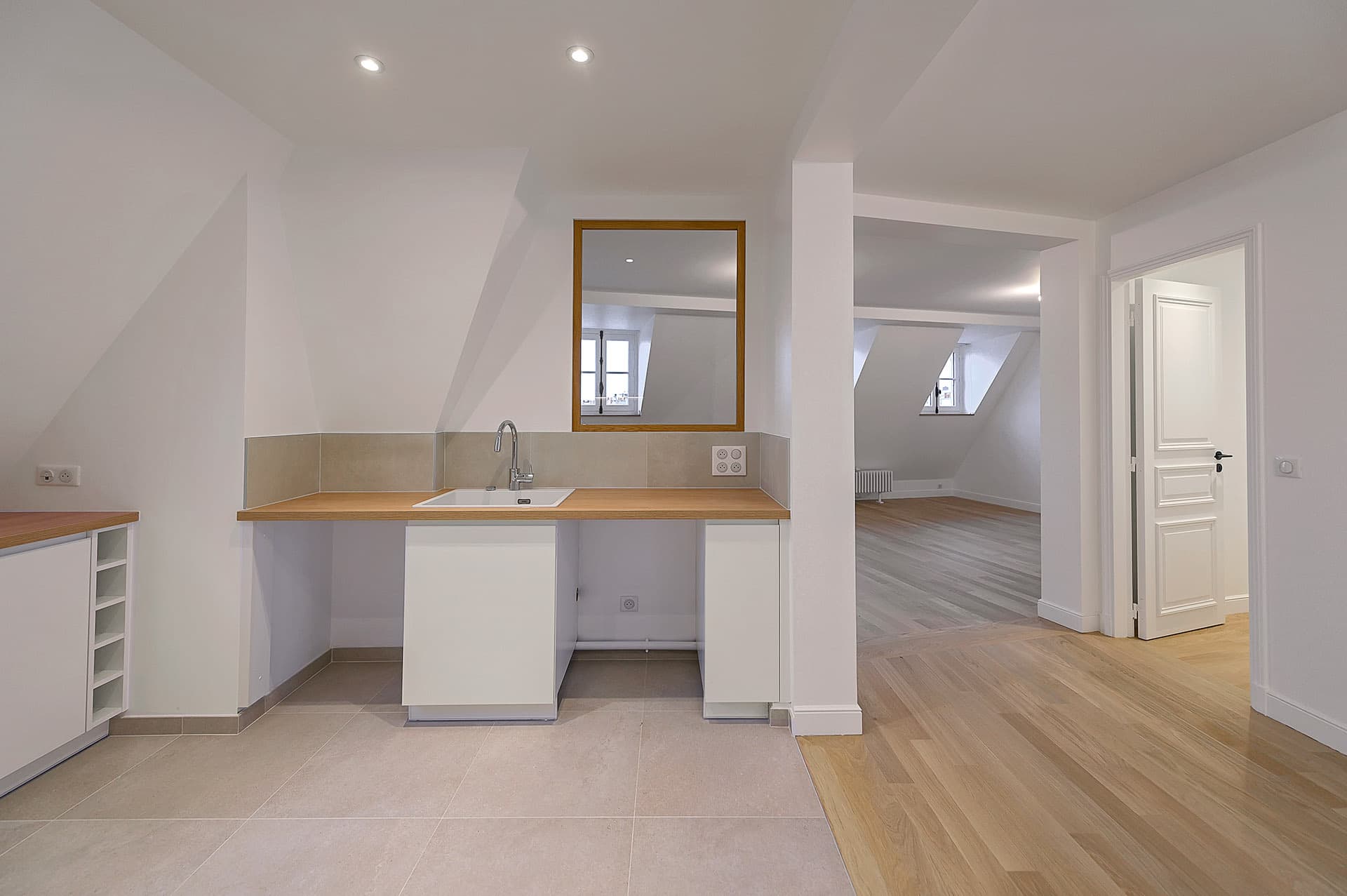 Cuisine ouverte sur un séjour avec sol carrelé et parquet