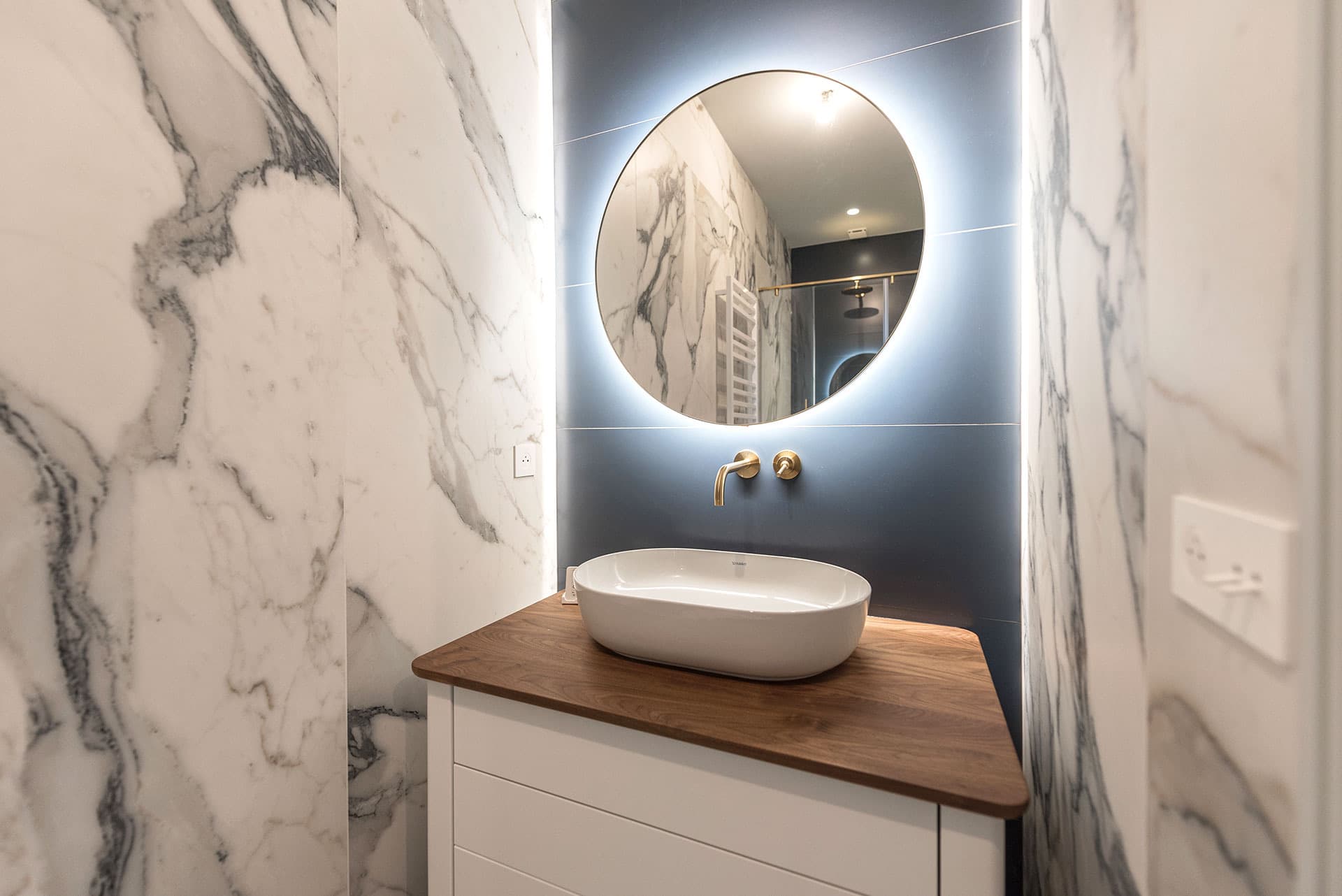 Lave-mains en marbre Calacatta avec robinetterie dorée et miroir rond rétroéclairé